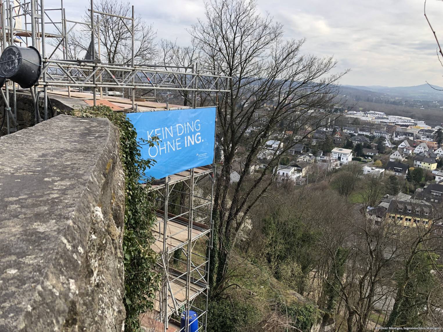KDOI-Bauzaunbanner an der historischen Stützmauer des Michalesberges in Siegen